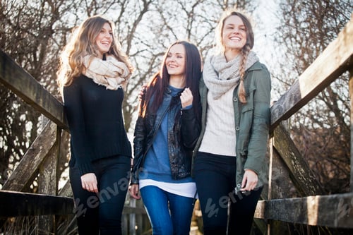 Preview: Three friends sharing a joyful moment outdoors on a sunny day