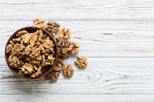 Preview: Fresh healthy walnuts in bowl on colored table background. Top view Healthy eating