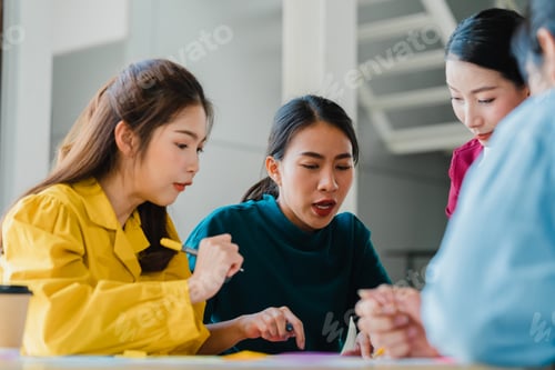 Preview: Asian businessmen and businesswomen meeting brainstorming ideas in small office.