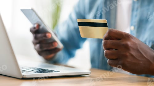 Preview: Black man using card and smartphone for paying bills online