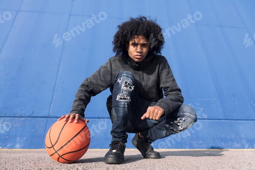 Preview: teen male in informal outfit with basketball ball
