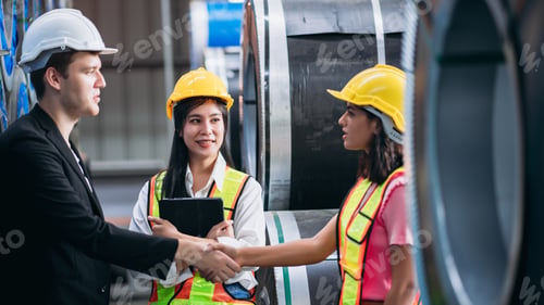 Preview: Team engineers and foreman stack hand and shake hands to show success at factory machines.