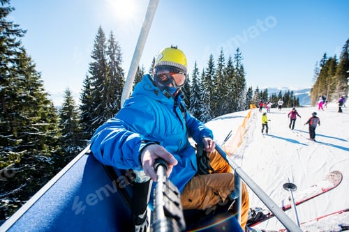 Preview: Male skier using selfie stick taking photos while skiing