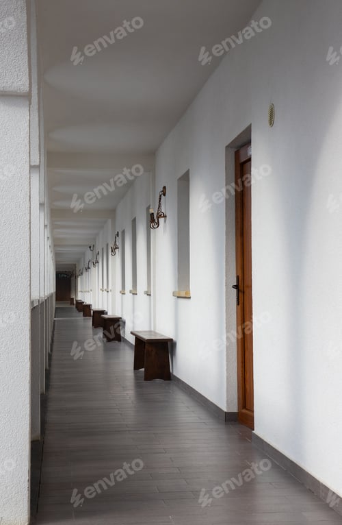 Preview: a hallway with many rows of wood benches on each side
