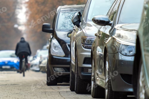 Preview: Cars parked in a row on a city street side.