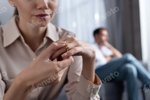 Preview: partial view of upset woman taking off ring and man on sofa
