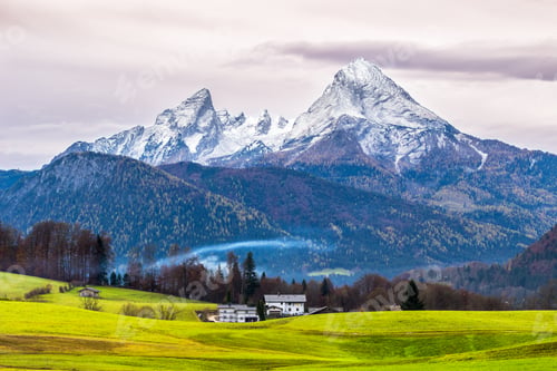 Preview: Green meadow and snow-capped Watzmann mountain on a background. Bavarian alps. Germany