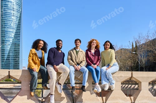 Preview: Young students sitting on a wall in the city