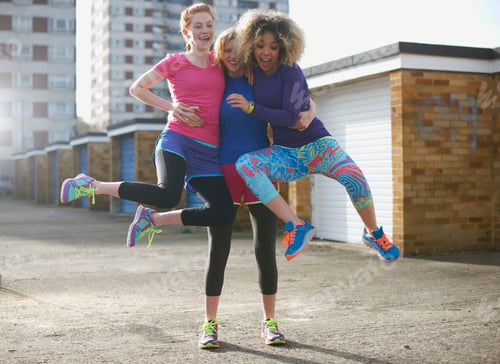 Preview: Portrait of three women wearing sports clothing jumping