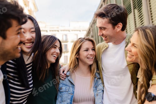 Preview: Friendly group of young friends laughing together in city street