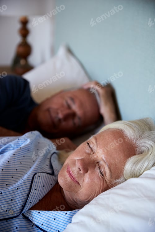 Preview: Senior white couple asleep in their bed, waist up, close up, vertical