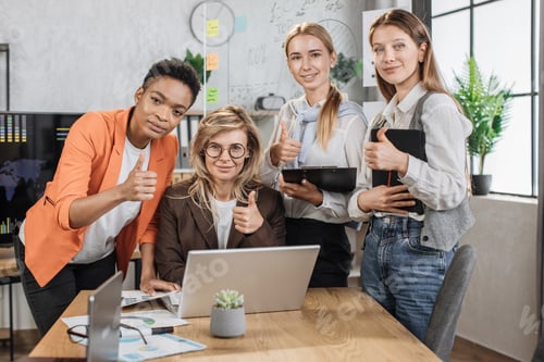 Preview: Beautiful senior female boss sitting at the table in office and listening to her diverse colleagues
