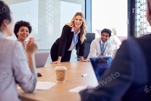 Preview: Businesswoman Leading Multi-Cultural Business Team Meeting And Collaborating Around Table In Office
