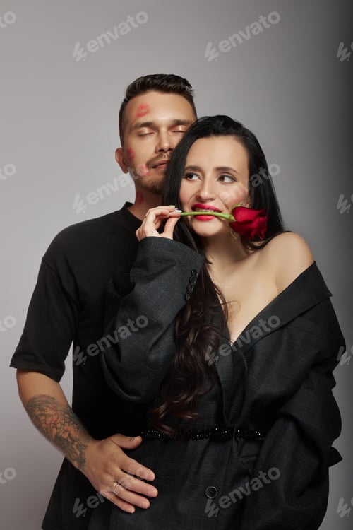 Preview: Couple poses with rose in studio setting during a photoshoot