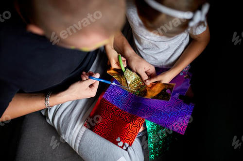 Preview: Daughter and father having fun making craft together at home on the sofa