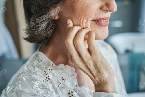 Preview: Hand of aging woman touching her face