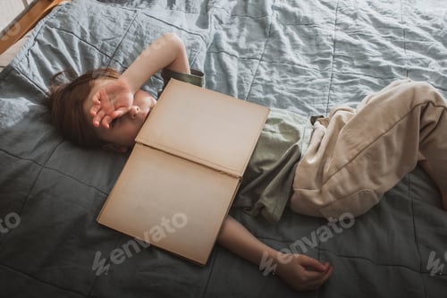 Preview: Tired Child Lying on Bed with Book