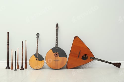 Preview: Set of different wooden musical instruments near white wall indoors