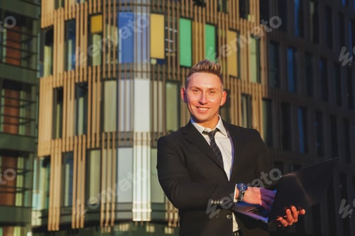 Preview: Young man businessman in style wear clothes, suit sitting on steps with laptop
