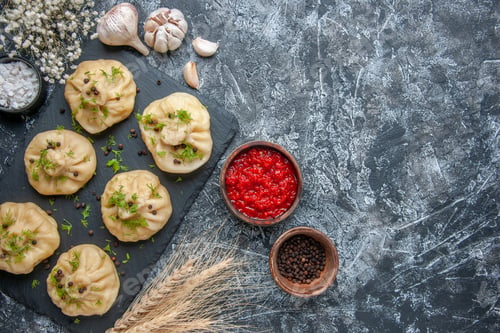 Preview: top view raw little dumplings with tomato sauce and garlic on light gray background meat cuisine