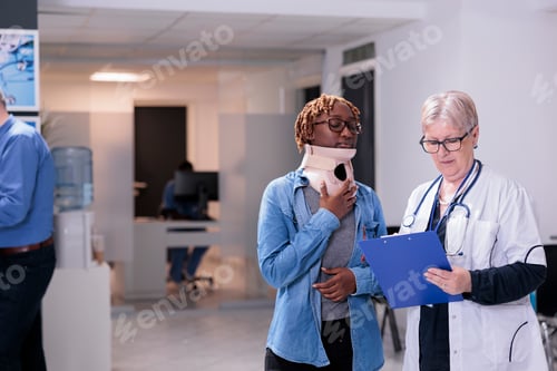 Preview: Doctor examining woman with neck collar