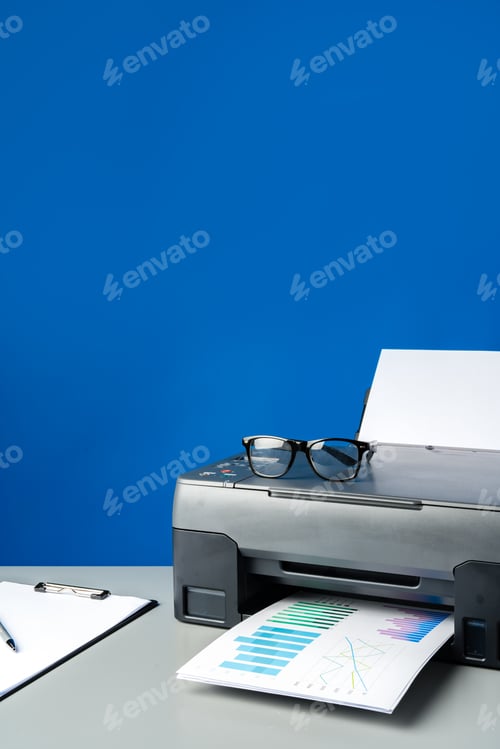 Preview: Laser printer on desk against blue background.