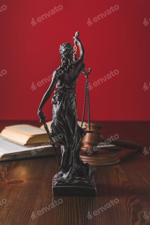 Preview: opened juridical books with lady justice statue on wooden table, law concept