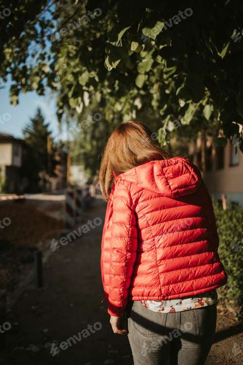 Preview: Vertical back view of a female wearing a bright red coat