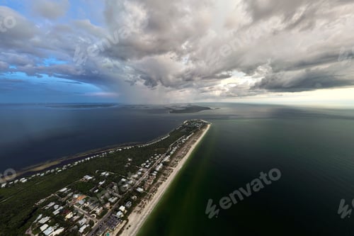 Preview: View from above of large storm approaching over residential houses in island small town