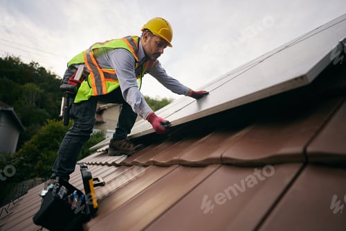 Preview: Below view of a worker mounting solar panel system on rooftop.