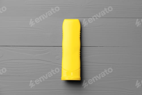 Preview: Yellow cosmetic container on gray background top view