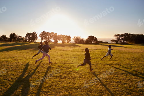 Preview: Four elementary school children running in an open field