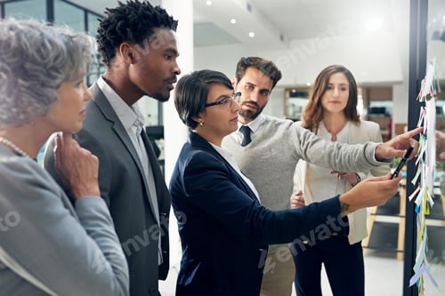 Preview: Shot of a group of businesspeople brainstorming on a glass wall in an office