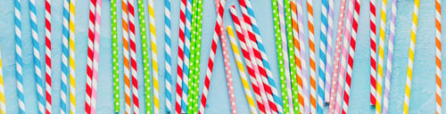 Preview: Drinking paper colorful straws for New Year cocktails on light blue background. Christmas card. Top