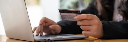 Preview: Businesswoman holding credit card while using laptop computer to buy or pay online, online shopping.