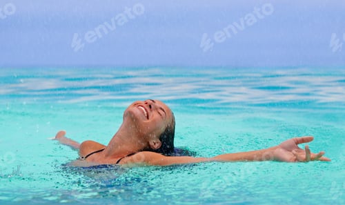 Preview: I could stay here forever...A gorgeous young woman enjoying the water with her arms outstretched.