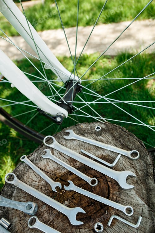 Preview: Tools, instrument for repairing bike on the wooden background outdoor wheel. Bicycle repair.