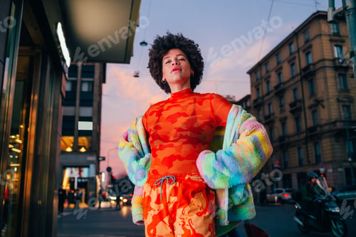 Vista previa: Proud young black woman posing outdoor city night strong and confident hands on hips