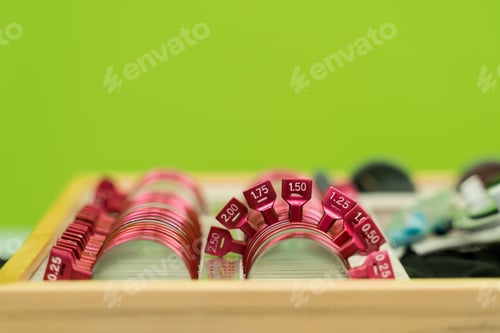 Preview: Ophthalmology trial frame lenses on green background for eye exam of patient vision power