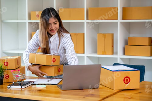 Preview: Portrait of Asian young woman SME working with a box at home the workplace.start-up small business o