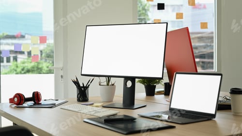 Preview: Creative office studio interior with laptop, blank screen computer, graphic tablet.