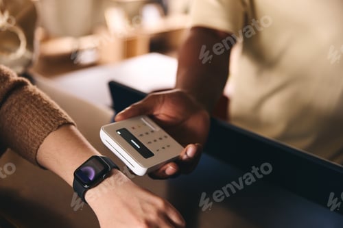 Preview: Customer Paying Using Smart Watch Mobile Payment NFC Contactless Technology In Retail Store