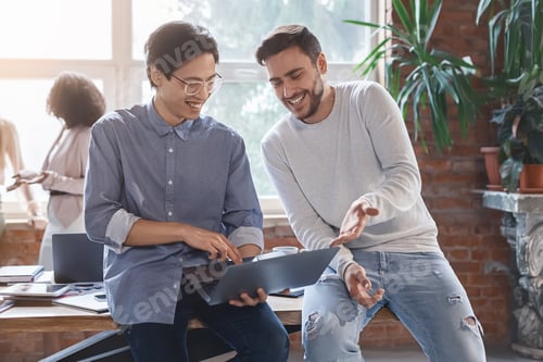 Preview: Two guys colleagues sharing creative ideas in casual office atmosphere