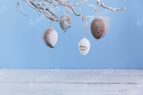 Preview: Easter eggs hanging on branch on pastel blue background