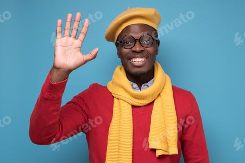 Preview: Inspired african man waving hand greeting his friends.