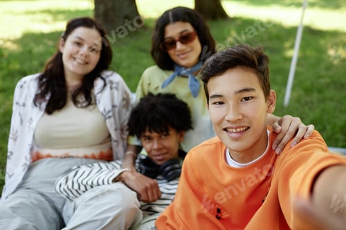 Preview: Portrait of Smiling Asian Boy Taking Selfie with Friends in Park