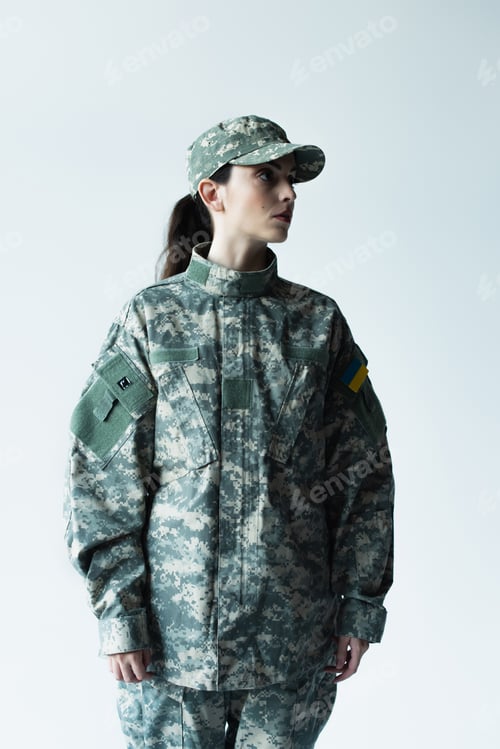 Preview: military woman with ukrainian chevron looking away isolated on grey
