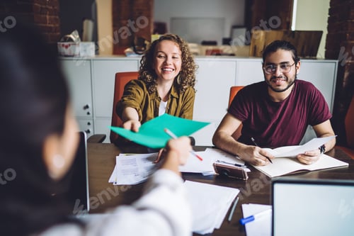 Preview: Satisfied multiethnic classmates researching with documents together at modern classroom