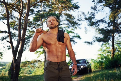 Preview: Handsome shirtless man with muscular body type is in the forest at daytime