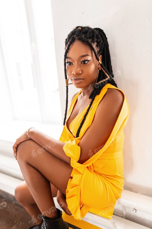 Preview: Glamorous woman in beautiful fashion summer yellow dress with dreadlocks. African American girl